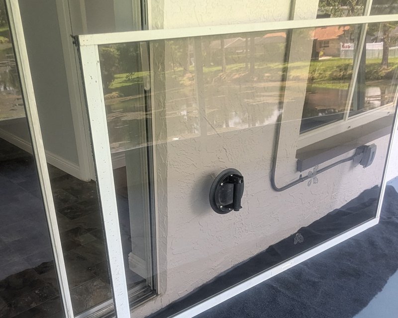 Technician repairing a sliding glass door, panel removed from track